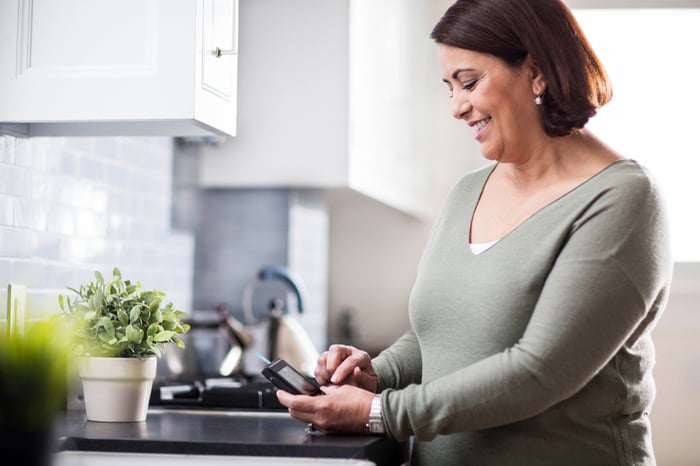 A woman checking her blood glucose readings on a connected device.