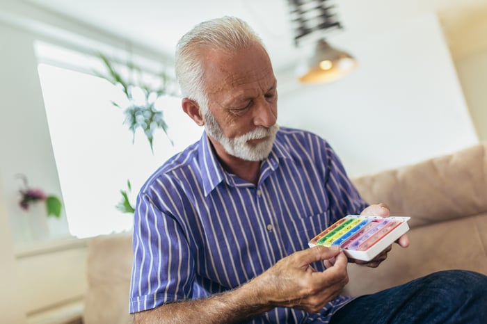 Older man holding a pill box