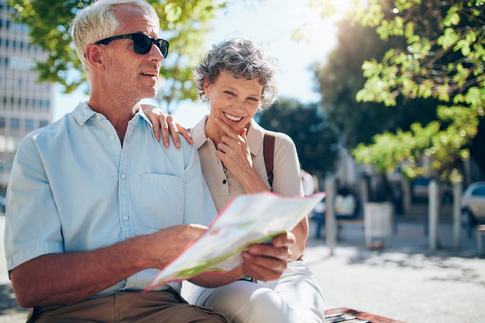 Smiling older man and woman holding a map