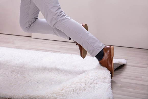 A person tripping on a rug.