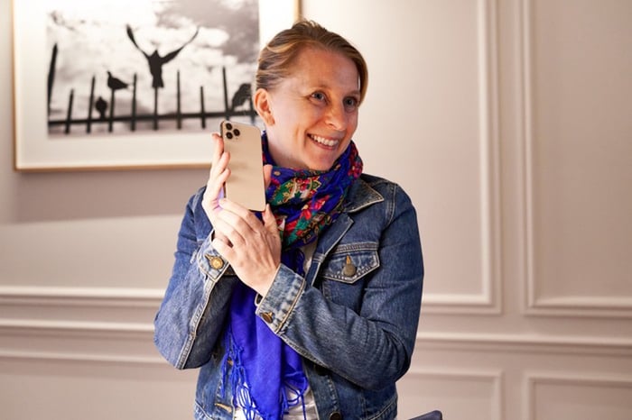 Wedbush Says Apple Is Worth Nearly $1.6 Trillion Female customer holding an iPhone 11 Pro