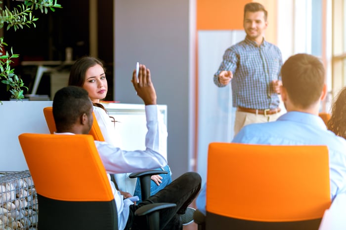 A corporate training class in a relaxed, modern office setting.