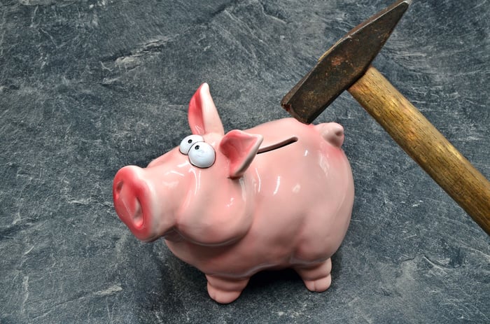 Hammer breaking a piggy bank.