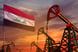 Oil pumps and an Iraqi flag with the sun setting in the bakground.