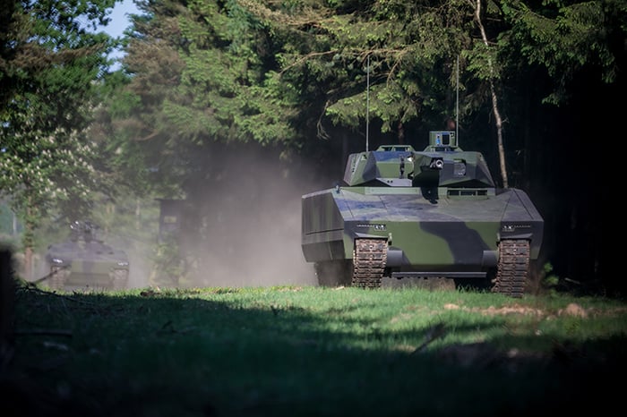 The Rheinmetall Lynx on maneuvers in a forest setting.