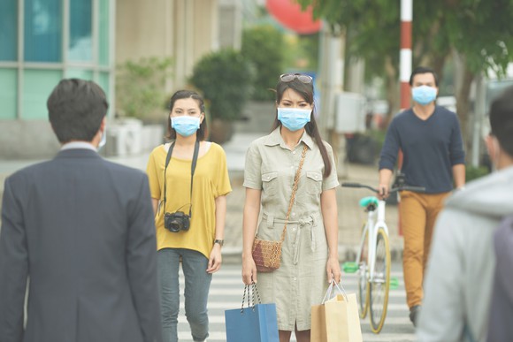 People with face masks on the sidewalk