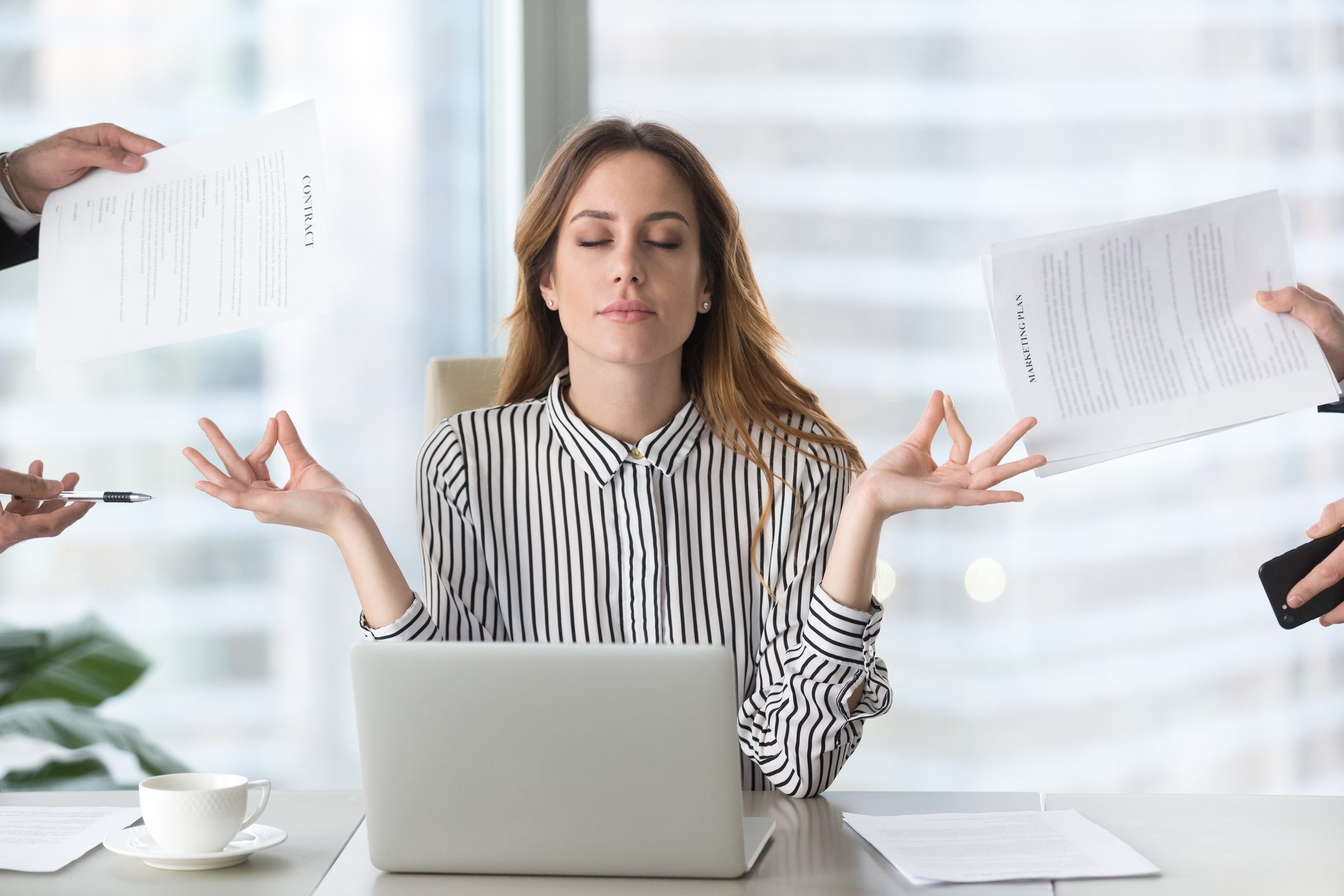 Woman at laptop meditating and ignoring distractions