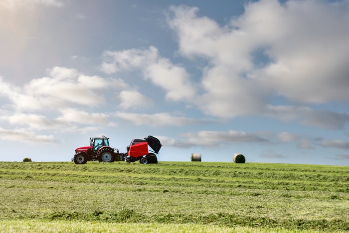 A red tractor is shown on a hill.