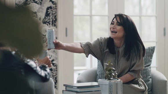 Woman holding can of Press hard seltzer