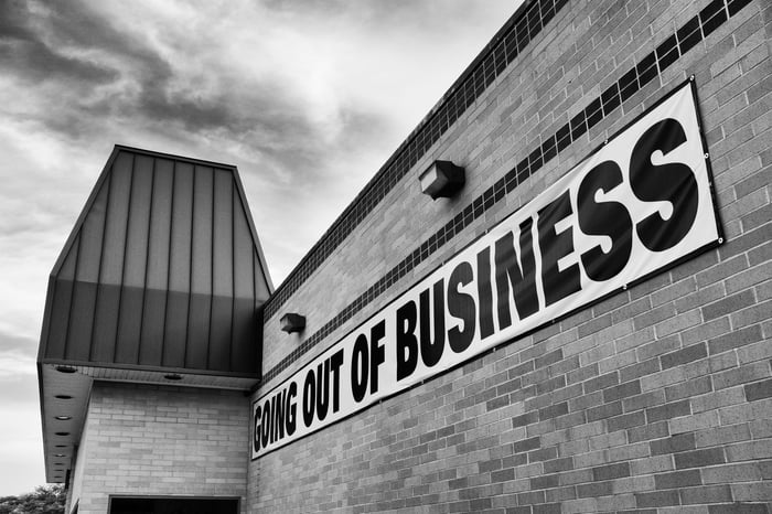 Going out of business banner on a brick store wall in black and white