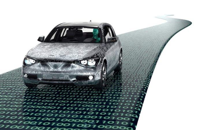 Computer rendering of a modern passenger car driving on a glossy black road covered in green zeroes and ones.