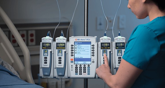 Technician pushing a button on an Alaris infusion system