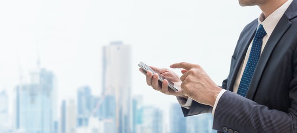 A businessman uses a smartphone.