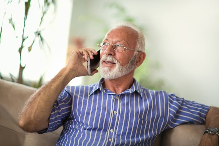 Older man holding cell phone to ear