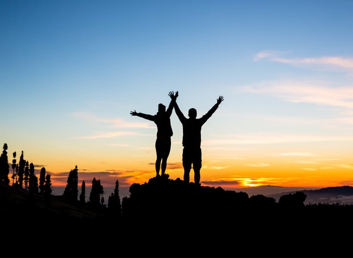 Couple celebrate reaching a mountain summit.