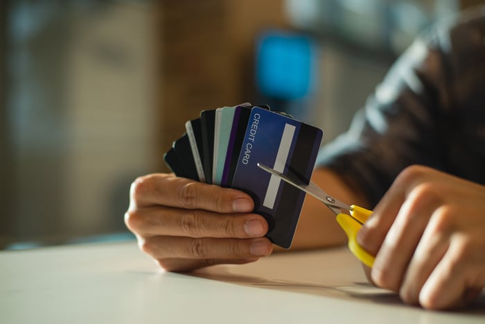 Hands holding scissors and cutting up an entire stack of credit cards