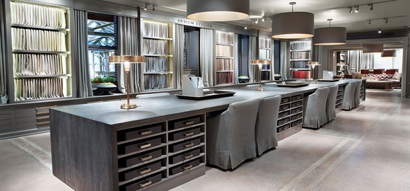 The interior of a RH store, with samples hanging on the wall and a large gray desk.