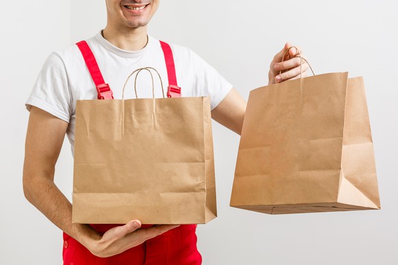 Restaurant delivery boy with two bags of food