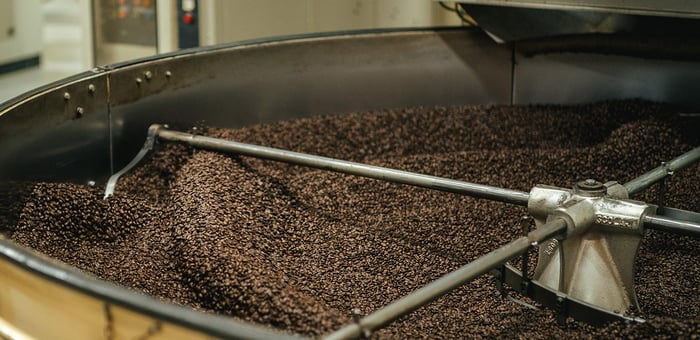 A large roaster full of coffee beans.