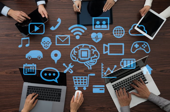 People working on different devices around a table.