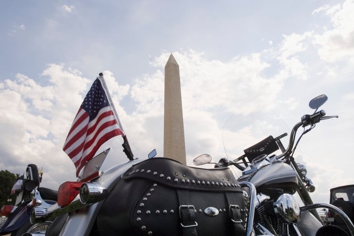 A motorcycle with an American flag parked in front of the Washington Monument