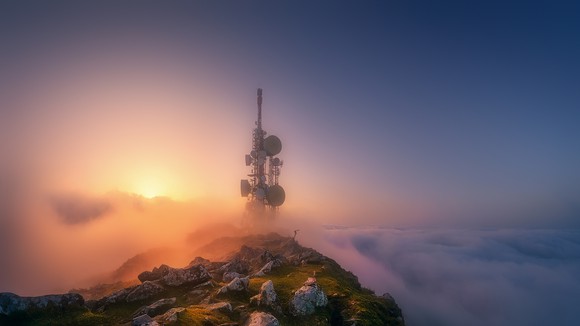 Communication tower on top of a cloud-covered mountain top.