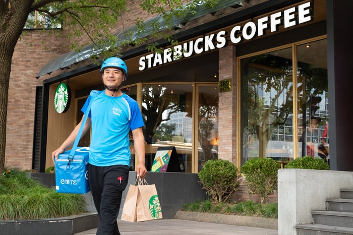 A delivery worker in front of a Starbucks store in China