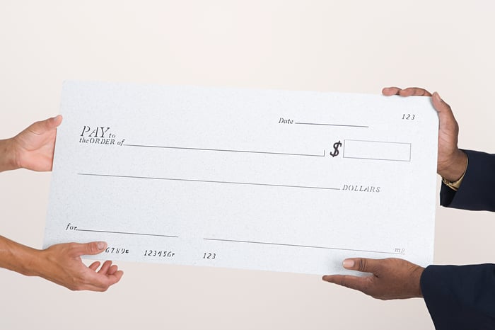 Large blank check being held by two people