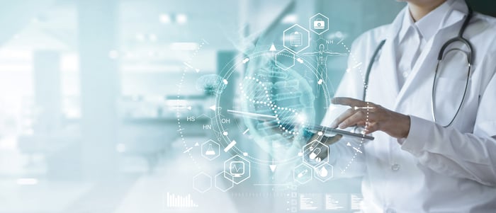 Medical professional holding a tablet in a hospital.