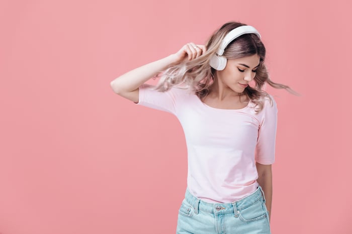 A young woman listening to music with headphones on.