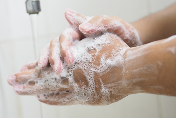 A man washing his hands with soap and water.