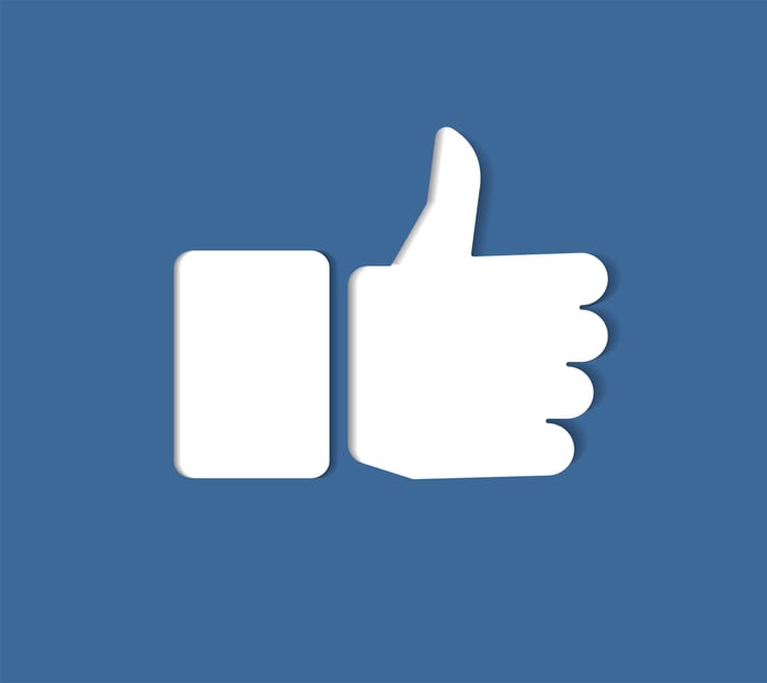 Facebook white thumbs up icon on a blue screen. 
