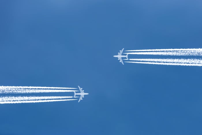 Two airplanes flying toward each other from opposite directions.