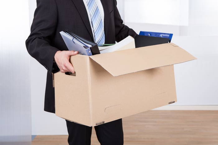 Man in suit carrying box of office supplies