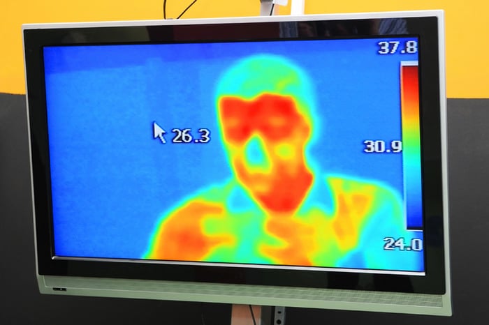 Screen showing infrared thermal image of a person from about the chest up.