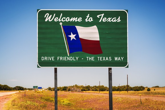 Road sign reads Welcome to Texas, Drive Friendly the Texas Way