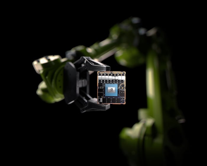 A robotic arm holding an NVIDIA chip