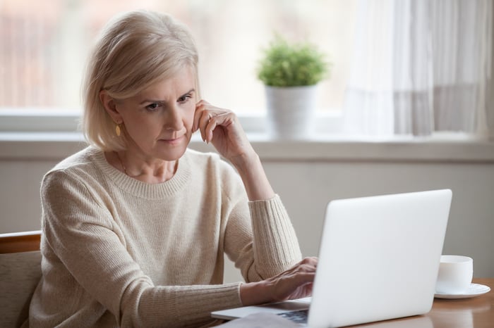 Older woman with serious expression at laptop