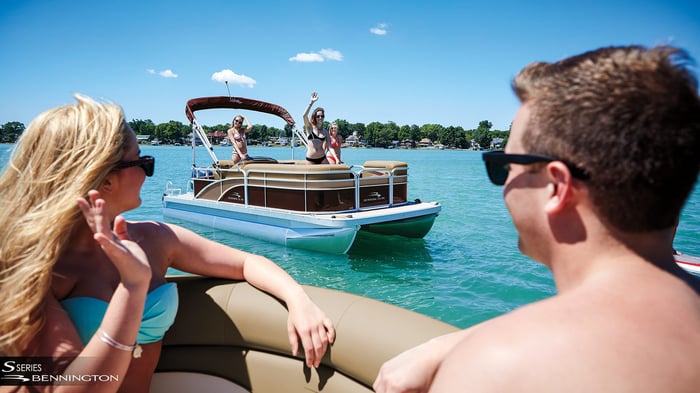 Couples on pontoon boats waving