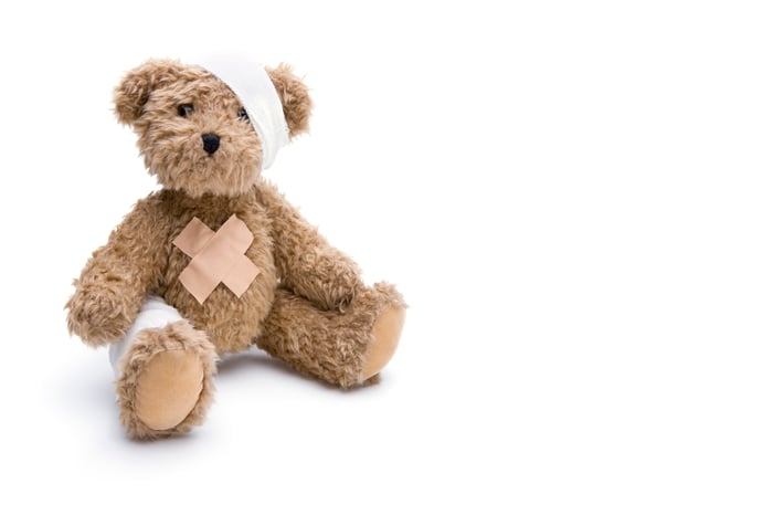 Photo of a teddy bear covered in bandages.