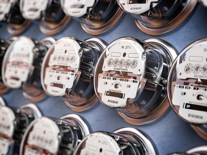 Multiple rows of electric meters on a utility panel. 