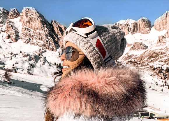 woman in fur lined winter jacket at ski resort.