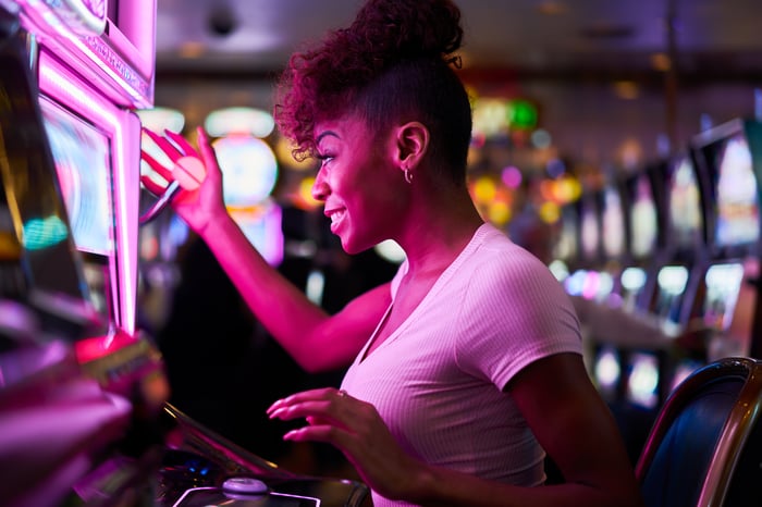 A woman at a slot machine.