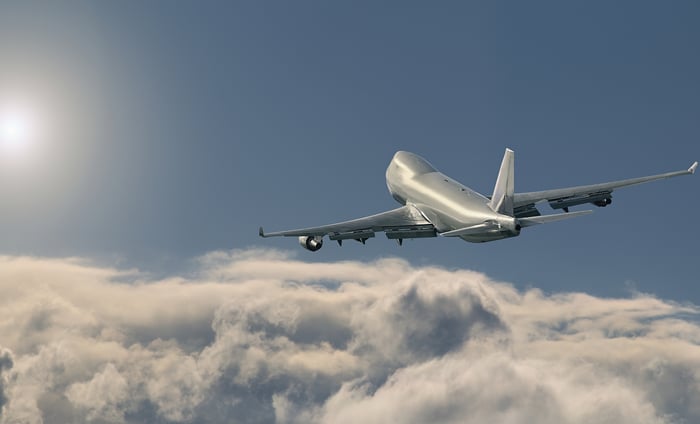 A jet airplane flying over clouds