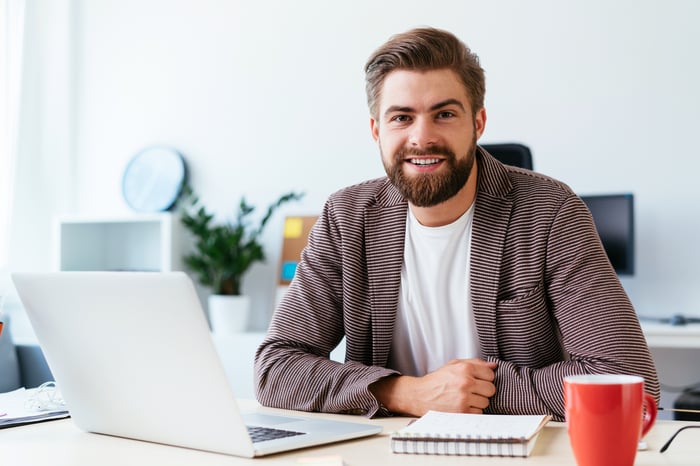 Smiling young man at laptop