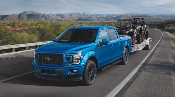 A blue Ford F-150 pickup towing a trailer