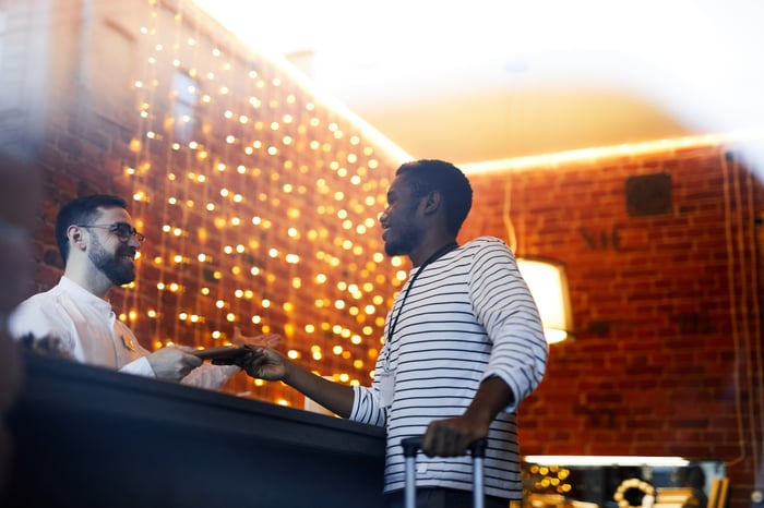 A hotel employee greeting a customer in a hotel lobby