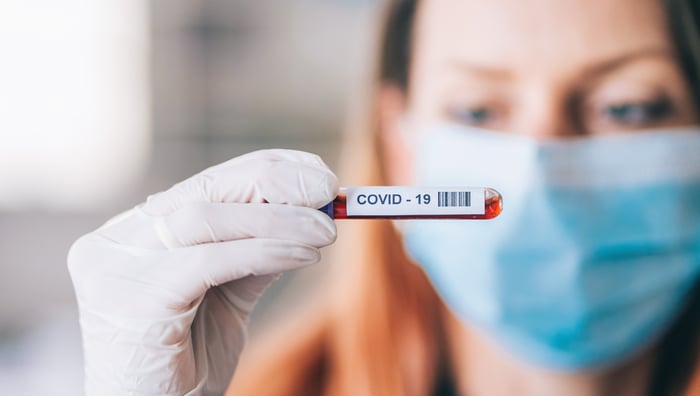 A doctor looks at a COVID-19 vial