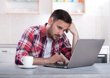 Man with sad expression at laptop_GettyImages-691199040