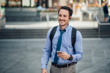 Smiling man outdoors holding cell phone_GettyImages-872840822